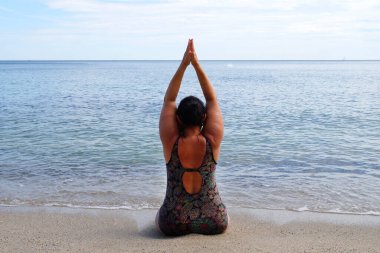 Ayyaş kadın deniz kenarında yoga yapıyor, doğada meditasyon yapıyor..