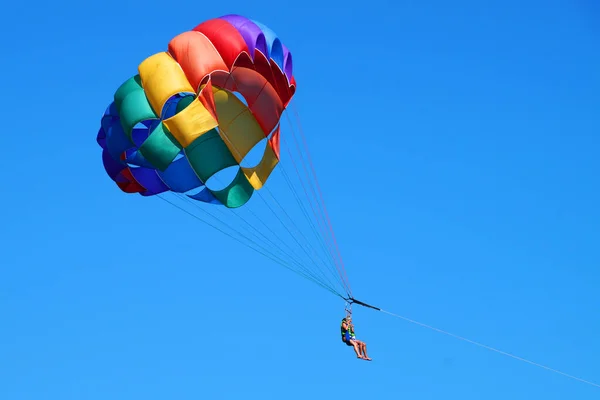 Paraquedas Multicoloridos Com Pessoas Sobre Mar — Fotografia de Stock