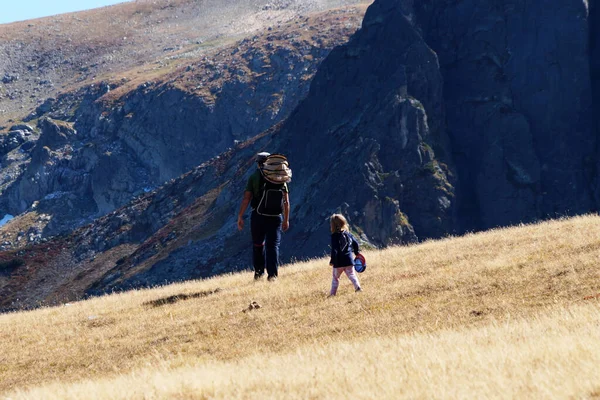 大きなリュックと小さな娘のいる男が山の中を旅して — ストック写真