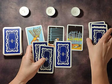 Kadın eli masaya tarot kartları serer. Solitaire düzeni..