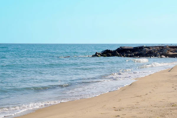 空の砂浜海岸の大きな石海の地平線澄んだ空 — ストック写真