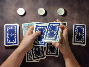 female hands shuffle tarot cards, solitaire layout close-up