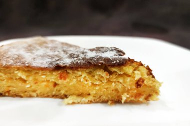 Bir dilim turuncu turta, beyaz tabakta, yakın plan.