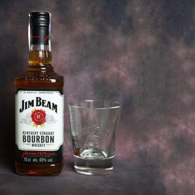 Varna, Bulgaristan - 13 Aralık 2021: Jim Beam viski şişesi ve koyu renkli arka planda viski için bir bardak