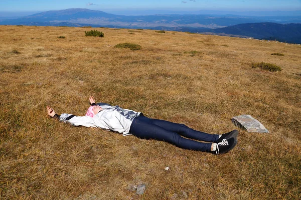 地面に寝そべって山に眠る少女は — ストック写真