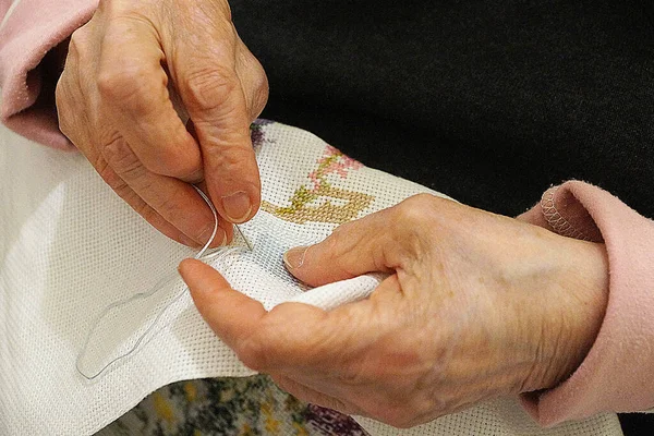 Elderly Woman Embroidering Cross Stitch Picture Hands Close Obrazy Stockowe bez tantiem