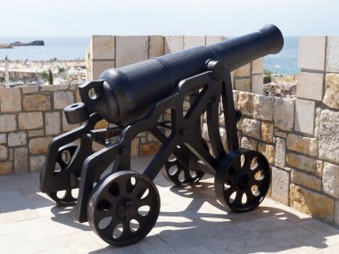antique cannon aimed at the sea on the fortress wall.