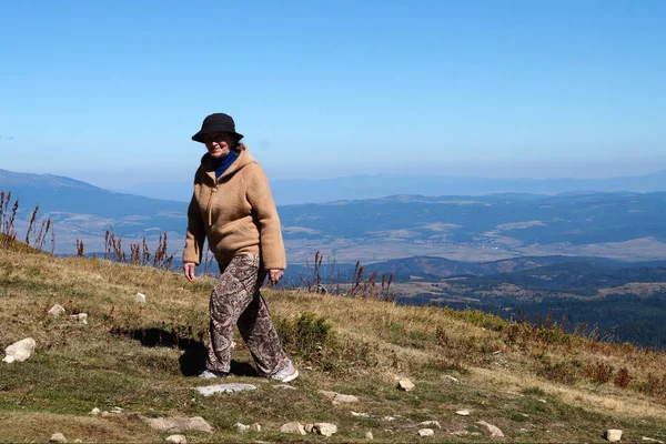 笑顔のおばあさんが晴れた日に山に登ると — ストック写真