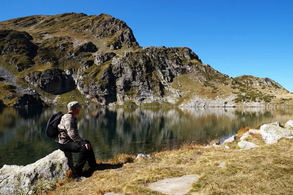 Homem Sentado Uma Pedra Admirando Lago Montanha — Fotografia de Stock