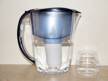 Bir sürahi içme suyu filtresi ve bir bardak temiz su.