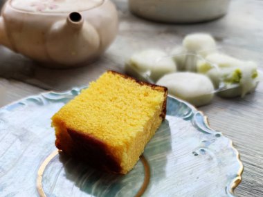 Yumurtalı bisküvi, Japon mochi tatlısı ve çaydanlık masada..