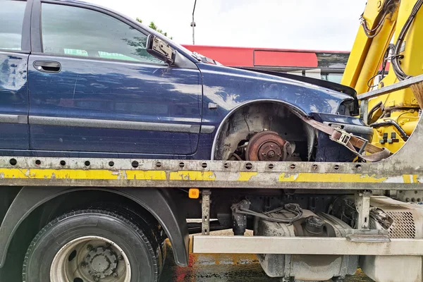 A tow truck carries a car that was wrecked in an accident close-up