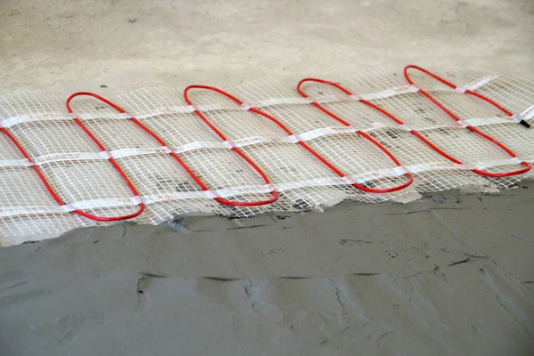 cable electric underfloor heating partially under cement screed close-up