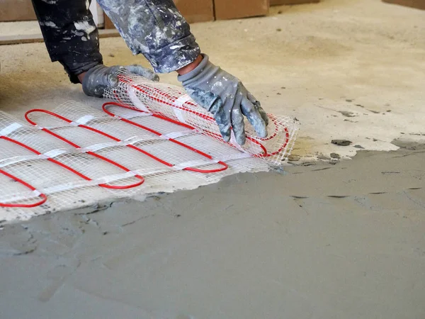 Worker Unfolds Roll Warm Electric Floor Laying Cement Screed Close — Fotografia de Stock