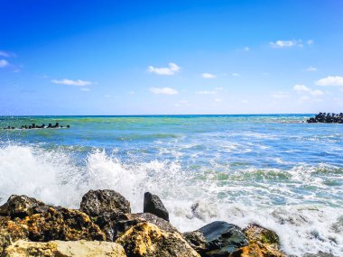 Mavi suyu, kayaları ve mistik yaz gökyüzü olan deniz kıyısı