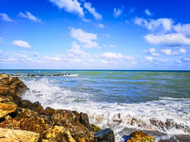 Mavi suyu, kayaları ve mistik yaz gökyüzü olan deniz kıyısı