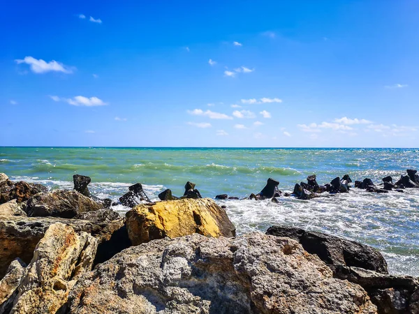 Mavi suyu, kayaları ve mistik yaz gökyüzü olan deniz kıyısı