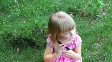 Küçük kız telefonda konuşuyor.