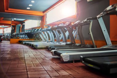 Spor salonunda koşu bantları. seçici odaklanma, düşük odaklanma derinliği. Sanatsal etki için küçük bir tahıl.