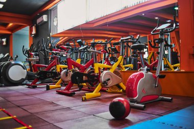 Spor salonundaki çeşitli egzersiz makineleri. seçici odaklanma, düşük odaklanma derinliği. Sanatsal etki için küçük bir tahıl