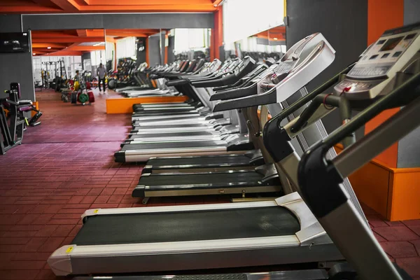 Spor salonunda koşu bantları. seçici odaklanma, düşük odaklanma derinliği. Sanatsal etki için küçük bir tahıl.