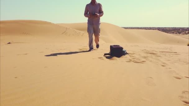 Un hombre con sombrero va a encontrarse con la cámara en el desierto — Vídeo de stock