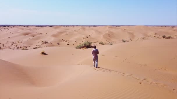 Vista de um homem em pé no deserto. — Vídeo de Stock