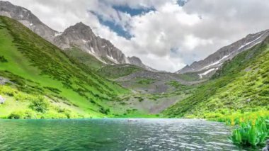 Turkuaz alp gölünde hızlı hareket eden bulutlar.