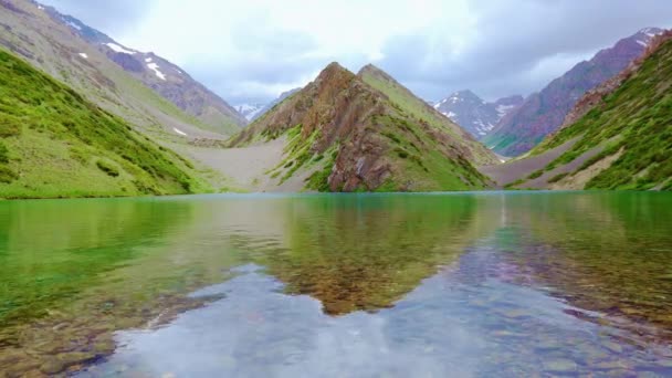 Adrone desde una vista de pájaro vuela sobre un hermoso lago de montaña. — Vídeo de stock