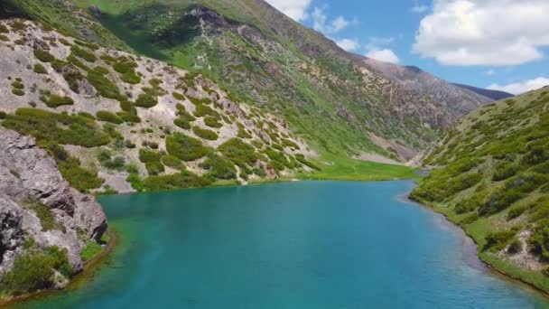 A drone flies over a turquoise mountain lake — 비디오