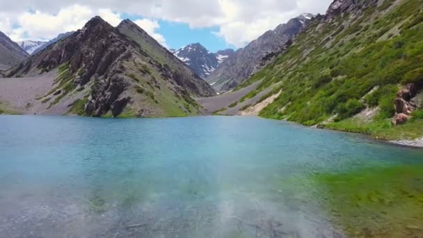 Sebuah pesawat tak berawak terbang di atas danau pegunungan pirus — Stok Video