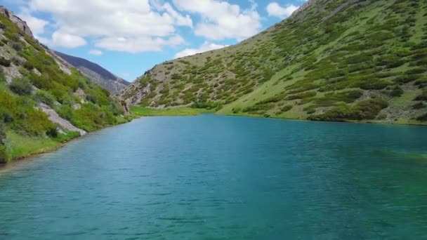Nad tyrkysovým horským jezerem přeletí dron — Stock video