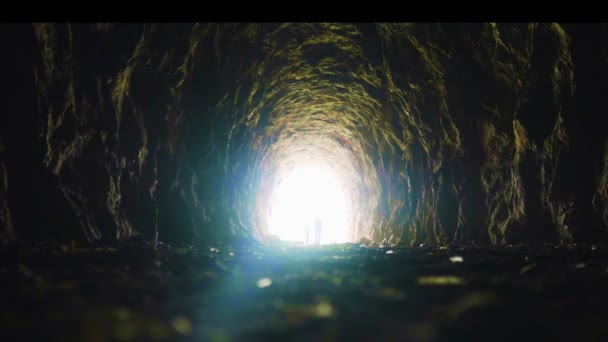 Twee mensen lopen door een tunnel van licht. — Stockvideo