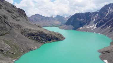 Kırgızistan 'ın buzul dağlarında Alakol Gölü. Orta Asya dağlarındaki görkemli bir dağ gölü üzerinde insansız hava aracı uçuşu.