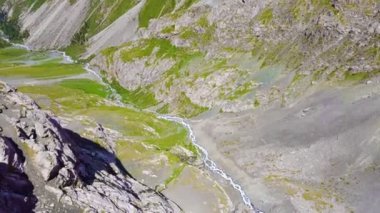 Kırgızistan 'ın buzul dağlarında Alakol Gölü. Orta Asya dağlarındaki görkemli bir dağ gölü üzerinde insansız hava aracı uçuşu.