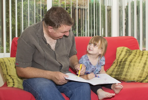 Padre e hija dibujando un cuadro juntos Imagen de archivo