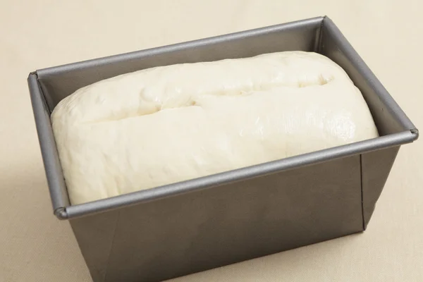 Risen bread dough in a tin — Stock Photo, Image