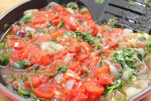 Tomatoes parsley and onion frying — Stock Photo, Image