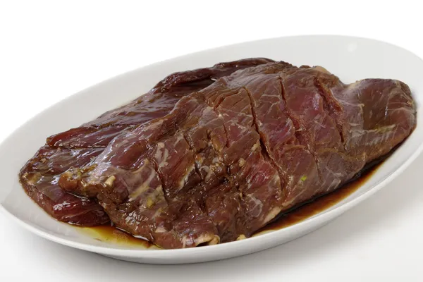 Marinaded flank steak on a plate — Stock Photo, Image