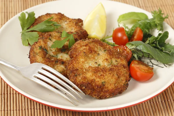 Pasteles de pescado empanados caseros con una ensalada — Foto de Stock