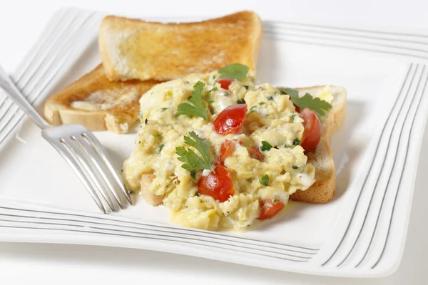 Scrambled egg and tomatoes on toast — Stock Photo, Image