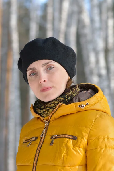 Woman in black beret and a yellow jacket. — Stock Photo, Image