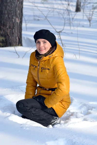 Porträt einer Frau, die im Schnee sitzt — Stockfoto