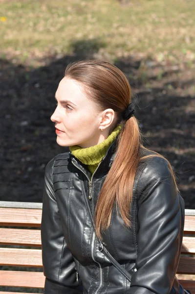 Frau sitzt an einem sonnigen Tag auf einer Bank — Stockfoto