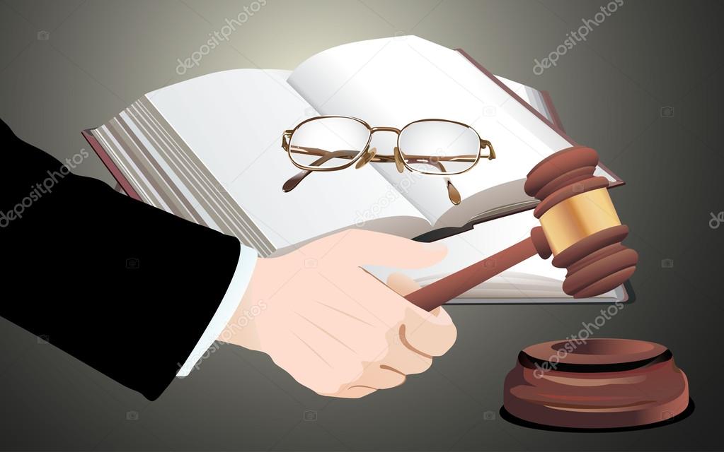 Wooden gavel in hand and law books
