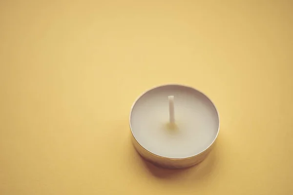 Eine Niedrige Weiße Kerze Auf Gelbem Tisch — Stockfoto