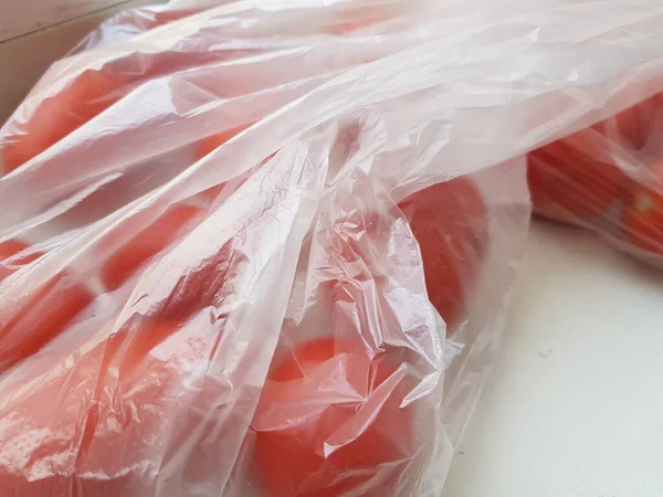Zamknij Czerwone Pomidory Torbie Celofan Białym Stole — Zdjęcie stockowe