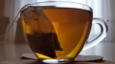 Glass cup with black tea on the wooden table
