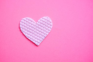 Pembe masadaki beyaz kumaş kalp. Sağ taraftaki boşluğu kopyala. Sanat aşk kartı.