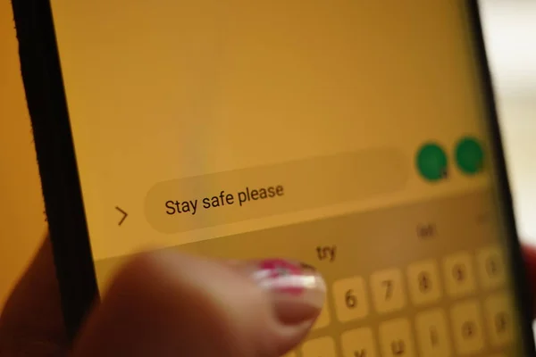 Młoda Kobieta Wpisując Stay Safe Proszę Wiadomość Białym Ekranie Smartfona — Zdjęcie stockowe